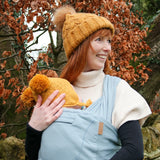 Front of mother carrier a baby in a Close Caboo Organic Baby soft structure cotton Carrier in sage 