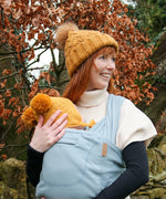 Front of mother carrier a baby in a Close Caboo Organic Baby soft structure cotton Carrier in sage 