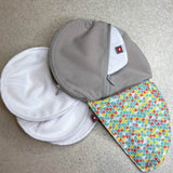 Close maternity breast feeding pads on a grey floor next to the Close pastel print pad pouch