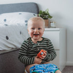 Young child sitting on a yellow potty in a bedroom