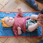 A little baby wearing The Close Parent Pop-in reusable nappy wrap cover with velcro closures, in a sloth print
