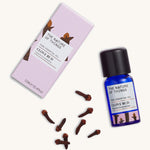 Organic Clove Bud pure essential oil in a blue glass bottle next to a decorative pink cardboard box, with cloves.