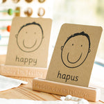 Coach House Welsh emotions flashcard stood in the Welsh emotions flashcard stand on a wooden worktop