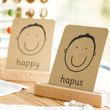 Coach House Welsh emotions flashcard stood in the Welsh emotions flashcard stand on a wooden worktop