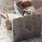  full of baby products for changing time. In the side pocket is a small rabbit toy