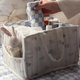  full of baby products for changing time. In the side pocket is a small rabbit toy