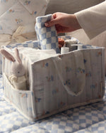  full of baby products for changing time. In the side pocket is a small rabbit toy