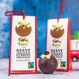 2 Cocoa Loco giant christmas chocolate pudding truffles on a white and blue background next to a glass bauble