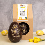 Cocoa Loco fairtrade dark chocolate and ginger easter egg on a beige worktop next to some mini easter eggs and a daffodil