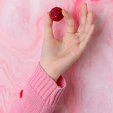 A person holding a Cocoa Loco Gin Truffle between their fingers