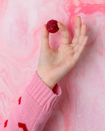 A person holding a Cocoa Loco Gin Truffle between their fingers