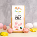 Cocoa Loco eco-friendly raspberry chocolate pigs on a cream worktop next to some pink and white easter eggs and daffodils