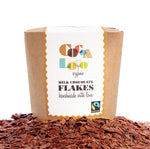 Box of Cocoa Loco organic fairtrade milk hot chocolate flakes on top of a large pile of chocolate flakes