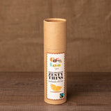 Tube of Cocoa Loco organic Fairtrade milk chocolate and orange thins on a wooden background
