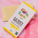 Cocoa Loco Organic Fairtrade Eco-Friendly White Chocolate Lemon Drizzle Bar laying underneath the packaging box
