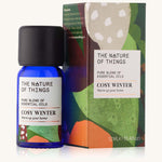 Cosy Winter Christmas pure essential oil blend in a blue glass bottle in front of a decorative festive cardboard box. 