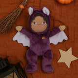 A purple coloured Olli Ella Bowie bat dinky dinkum doll soft toy. The dinky has dark coloured hair and lilac coloured inner wings and ears that glow in the dark. These soft toys are part of Olli Ella's Halloween collection available here at Babipur.
