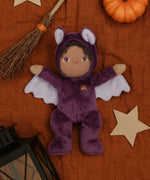 A purple coloured Olli Ella Bowie bat dinky dinkum doll soft toy. The dinky has dark coloured hair and lilac coloured inner wings and ears that glow in the dark. These soft toys are part of Olli Ella's Halloween collection available here at Babipur.
