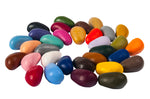 Kids coloured Crayon Rocks laid out in a circle on a white background