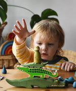 Stack of crocodile themed toys with a large Ostheimer crocodile, Lanka Kade crocodile, small Ostheimer crocodile and a Grapat animal Nin placed on top.