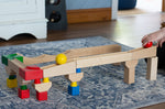 Nic Cubio wooden Ball Track Extension Set shown set up with a red  and yellow ball shown on motion on the track. Wooden balls are available to purchase separately. 