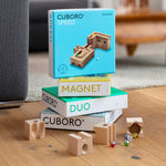 Cuboro plastic-free wooden marble run sets stacked on a wooden floor