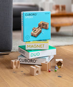 Cuboro plastic-free wooden marble run sets stacked on a wooden floor