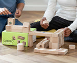 Close up of children playing with the Cuboro junior marble set, set up on the floor.