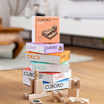 A stack of different Cuboro sets with pieces of the jump and kick sets on a wooden floor.