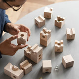 Cuboro standard 16 piece wooden marble run set being set up on a table by an adult. 