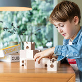 Cuboro standard 16 piece wooden marble run set up on a table, played with by a child. 