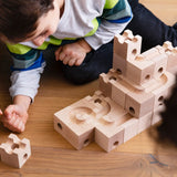 Cuboro Standard wooden marble run  32 piece set, set up on the floor with a child waiting for a marble to travel down the track.