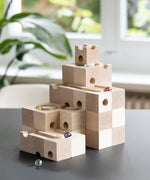 Cuboro standard 50 piece wooden marble run set up on a table with marbles placed in the track.
