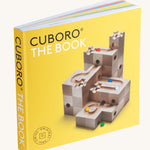 Cuboro marble run tips & tricks guide book stood up on a cream background showing the yellow cover