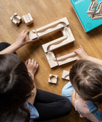 An overhead view of two children building the Cuboro Wave wooden marble run set