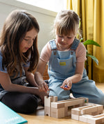 Two girls playing with the Cuboro WAVE wooden marble run set