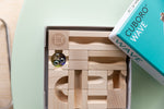 The Cuboro WAVE wooden marble run set in its box with the lid off, to show the beautiful natural wood grain.