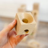 A close up of a wooden block from a Cuboro wooden marble set.