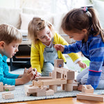 3 children playing with the Cuboro hand carved wooden marble run building blocks on a blue carpet