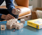 Cuboro standard 16 piece wooden marble run set being built on a table by an adult.