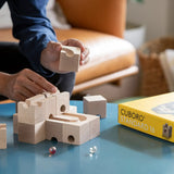 Cuboro standard 16 piece wooden marble run set being built on a table by an adult.