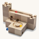 Cuboro Standard 16 piece wooden marble run building kit stacked on a cream background