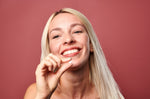 A woman holding a Denttabs toothpaste tablet