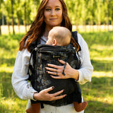 Mother carrying a baby in the Didymos didyfix full buckle baby carrier in blue blossom in the frontal position