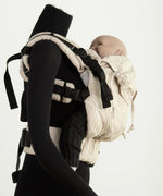 Side of Didymos didyfix carrier in linen cream shown on mannequin. A soft structured full buckle carrier made from cotton