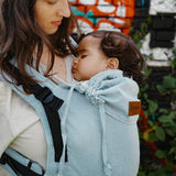 Side of mother carrying a baby in the Didymos didyfix soft structured baby carrier in ocean showing neck/head rest detail