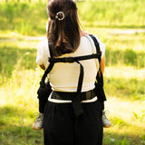 Back of mother wearing a didymos didyfix full buckle baby carrier in the frontal position showing padded shoulders and fastened buckles