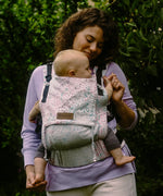 Mother carrying a baby in the frontal position in the Didymos didyfix soft structured full buckle carrier in summer mosaic