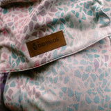 Summer mosaic design on the Didymos didyfix baby carrier showing a pink background with repeating pastel mosaic shapes and a brand patch on cotton fabric