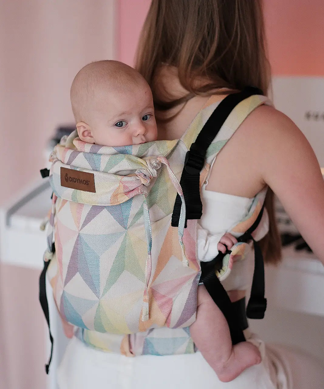 Mother carrying a baby in the Didymos didyfix soft structured cotton baby carrier in zephyr in the back position 